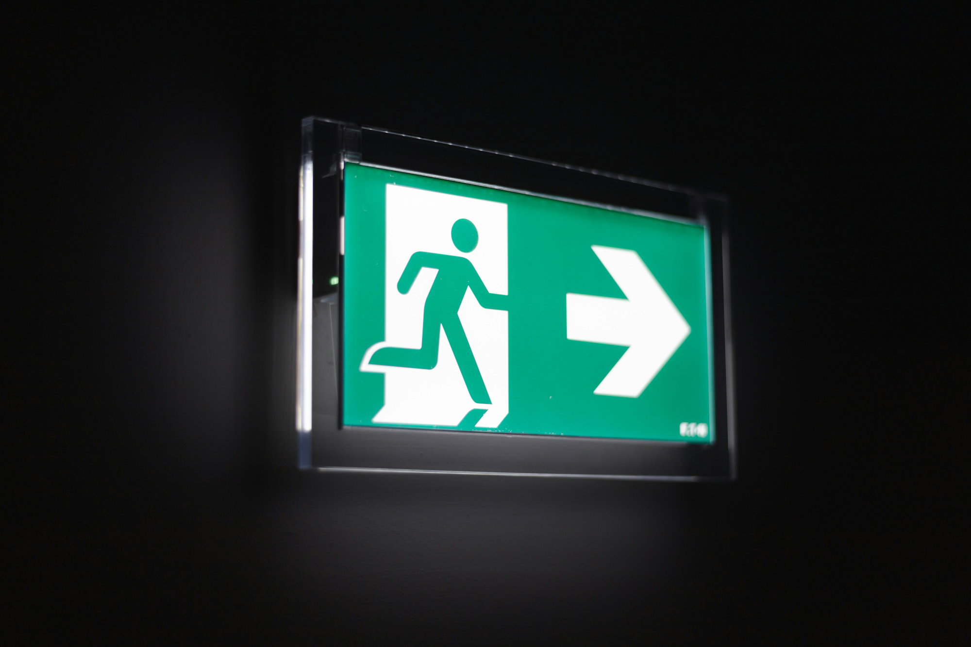 illuminated-green-exit-sign-with-a-running-figure-and-arrow.jpg Illuminated green exit sign with a running figure and arrow